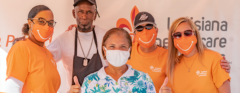 Three Louisiana Healthcare Connections employees and two cooks pose together while serving meals to people affected by Hurricane Laura in Lake Charles.